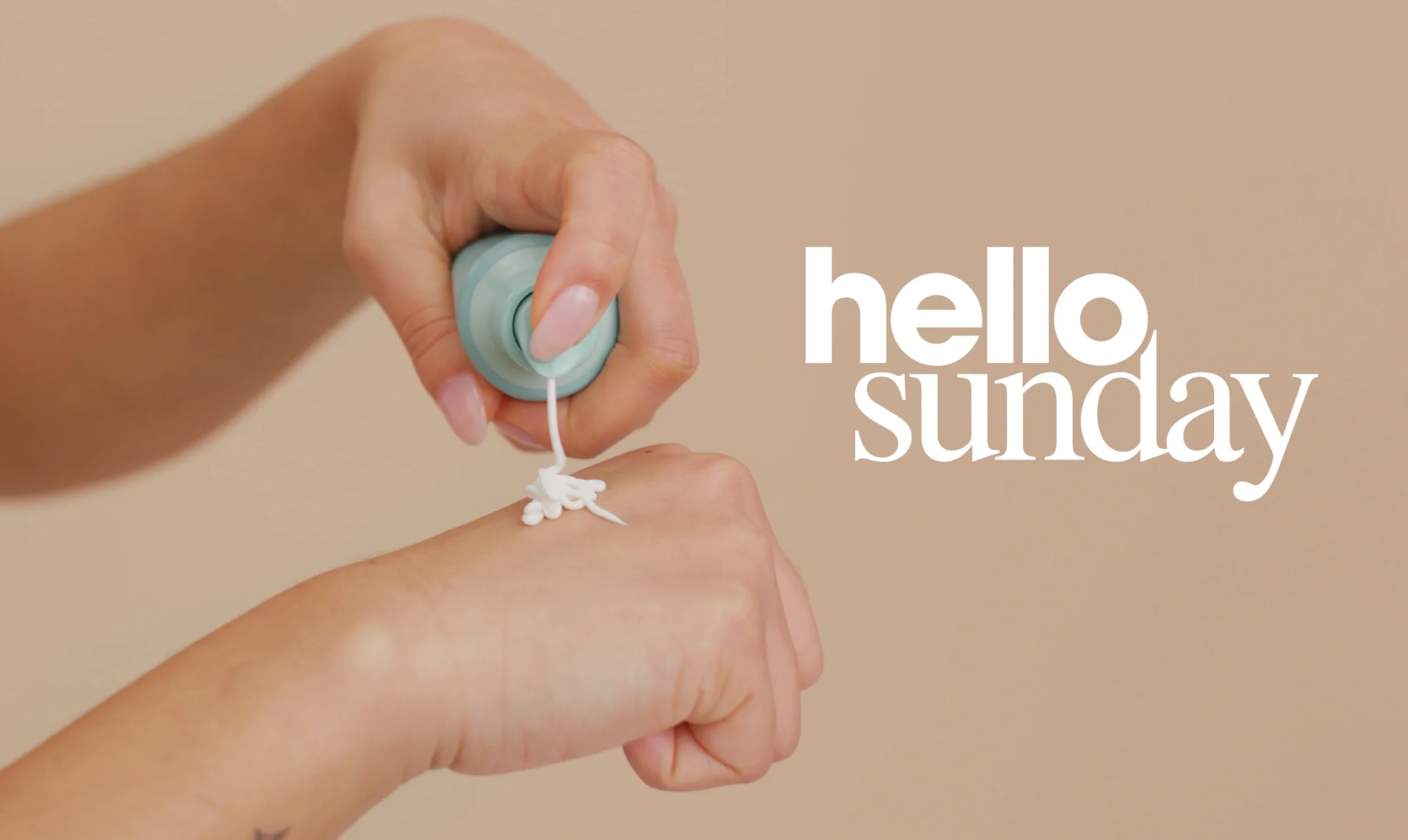 A hand applying Hello Sunday skincare from a white pump bottle.